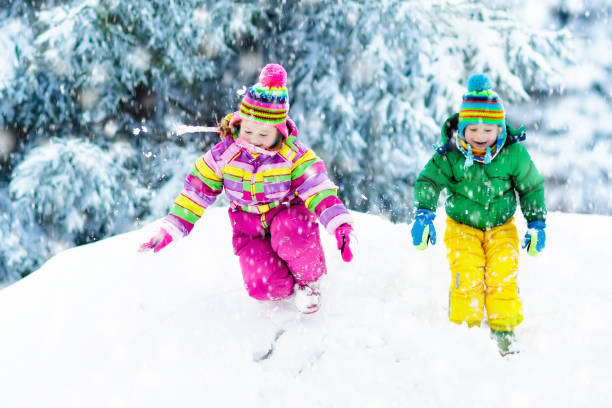 istock Kids playing in snow. Children play outdoors in winter snowfall. 857037614