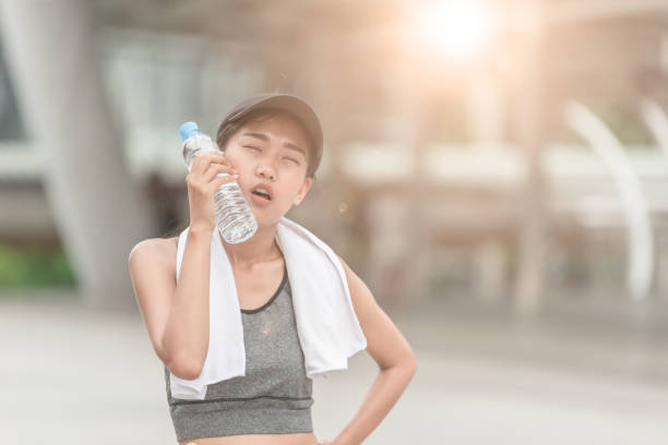 istock woman Wiping sweat Thirsty female jogger drinking 857037788
