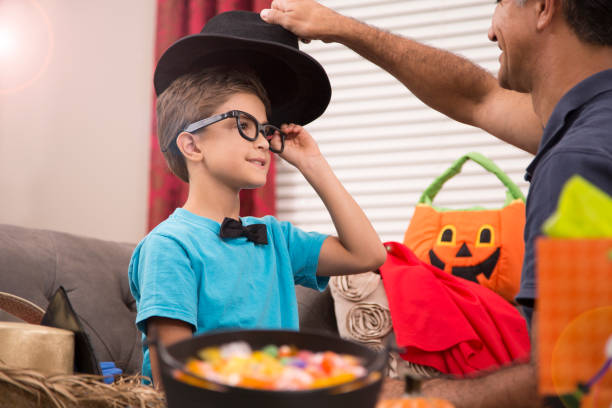 istock Little boy dresses up for Halloween with dad's help. 857038168