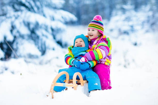 istock Kids on sleigh ride. Children sledding. Winter snow fun. 857040408