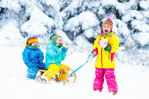 istock Kids on sleigh ride. Children sledding. Winter snow fun. 857040882