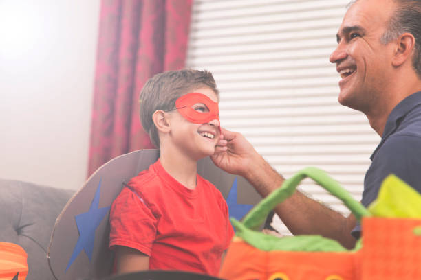 istock Little boy dresses up for Halloween with dad's help. 857041126