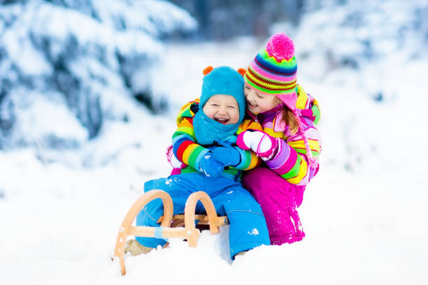 istock Kids on sleigh ride. Children sledding. Winter snow fun. 857044712