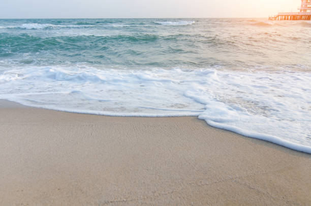 istock Blue and green waves cover golden sand on the shore 857048236