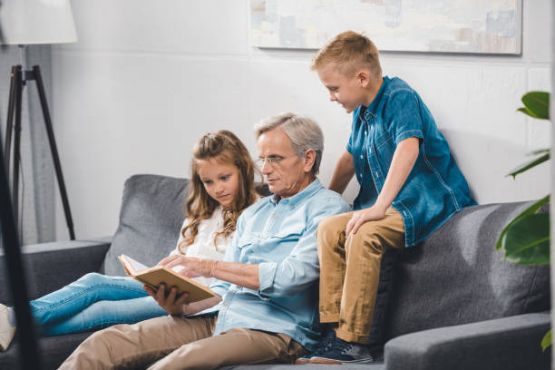 istock grandfather and grandchildren reading book 857048792
