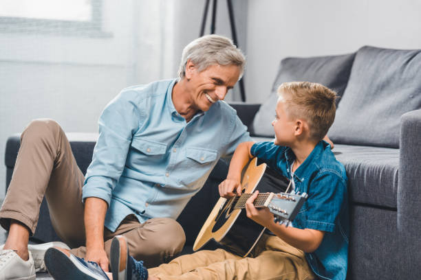 istock grandfather and grandson playing on guitar 857052372