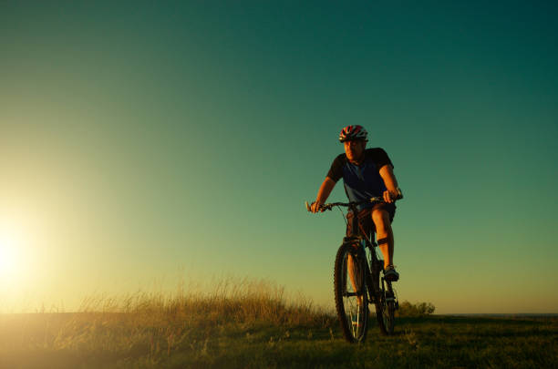 A young man riding a bicycle with high speed, focus on foreground.