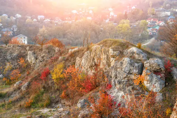 View on the beautiful colorful autumn landscape of the hills with trees, rocks and greenfields in the countryside.