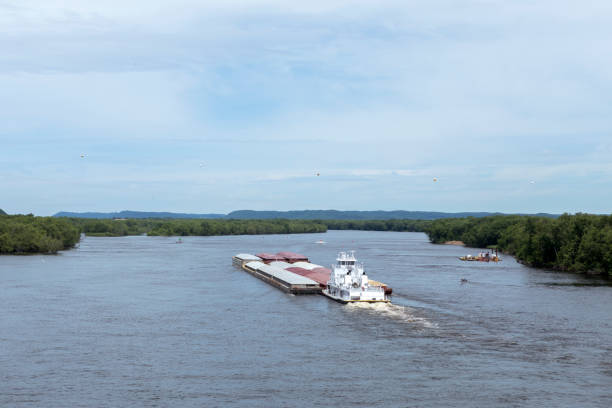 The towboat pushing a barge full of freight down the Mississippi River.