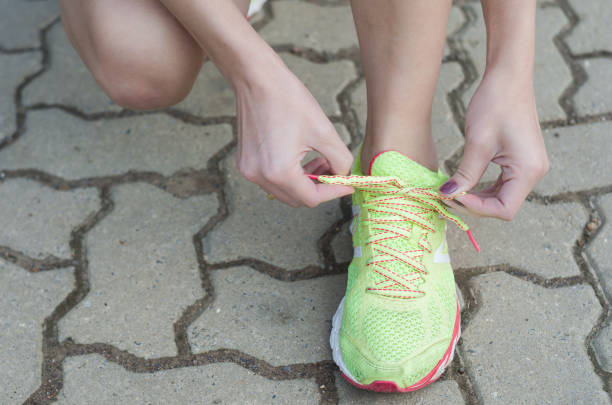 istock Running woman legs, closeup tying sneakers 857065470