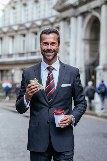 istock Man eating sandwich and drinking coffee on lunch break 857067676