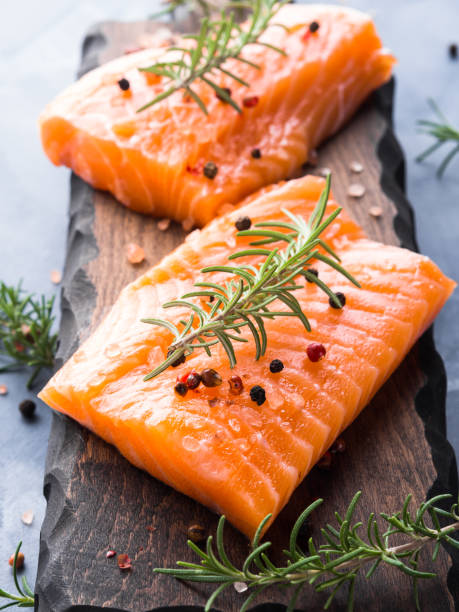 istock Raw salmon on wooden board with herbs 857068808