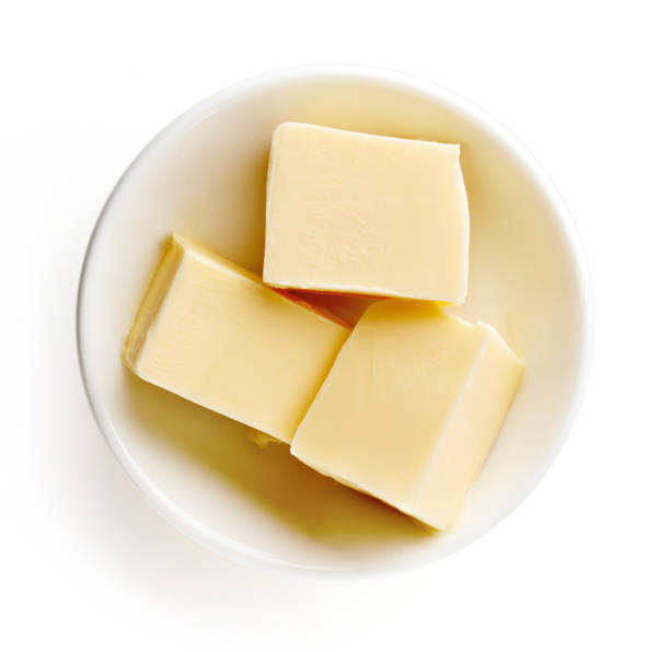istock Butter pieces in bowl isolated on white background, top view 857074920