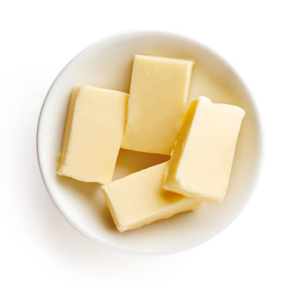 istock Butter pieces in bowl isolated on white background, top view 857074922
