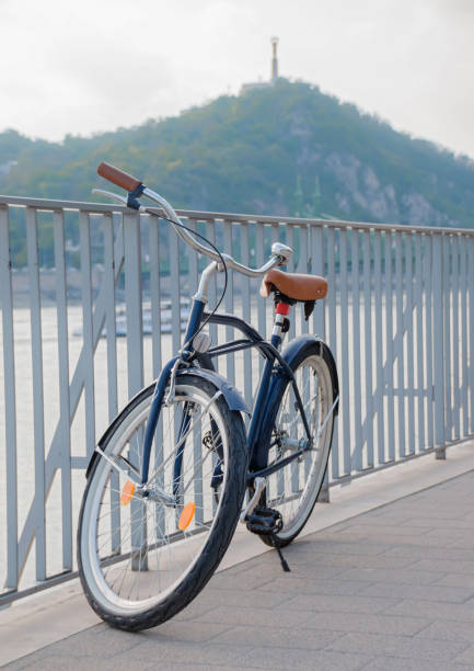 istock Retro style design bicycle parked next to river at urban environment 857081748