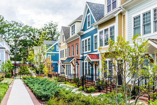 Fila de colores, rojos, amarillos, azul, blanco, verdes pintados viviendas adosadas, casas, casas con jardines de patio de ladrillo en verano photo