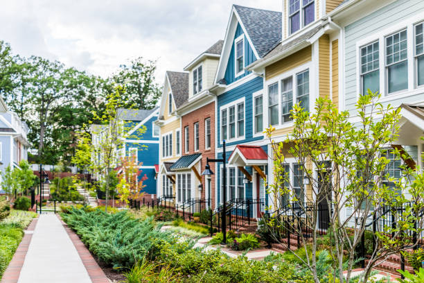 Row of colorful, red, yellow, blue, white, green painted residential townhouses, homes, houses with brick patio gardens in summer Row of colorful, red, yellow, blue, white, green painted residential townhouses, homes, houses with brick patio gardens in summer brick photos stock pictures, royalty-free photos & images