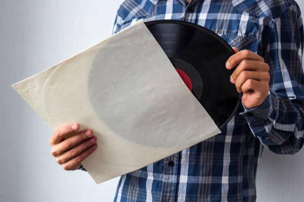mann mit vinyl-schallplatte - schallplatte hülle stock-fotos und bilder