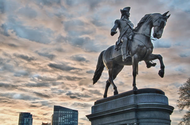 George Washington by Thomas Ball in the Boston Public Garden against a dramatic sunrise sky