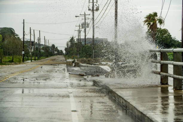 eau s’écrasant sur une route près de la baie de galveston juste en dehors de houston au texas - harvey photos et images de collection