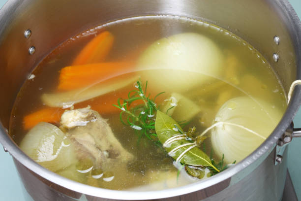 fare brodo di zuppa di pollo (brodo) in una pentola - brodo foto e immagini stock