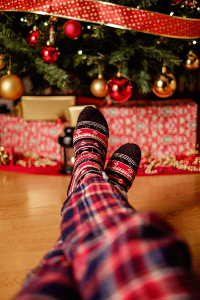 istock Female legs in front of christmas tree 857097802
