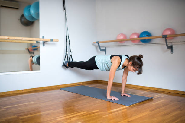 istock Woman exercising with trx in the studio 857098630