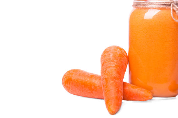istock Fresh orange carrot next to vitamin smoothie isolated on a white background. Whole vegetables for healthy beverages. 857099222