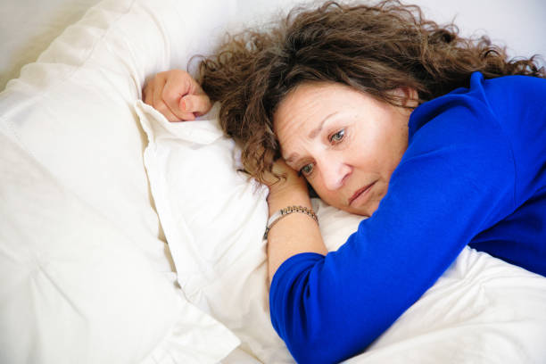 istock Sad Mature Caucasian female lying down on bed pensive 857100154