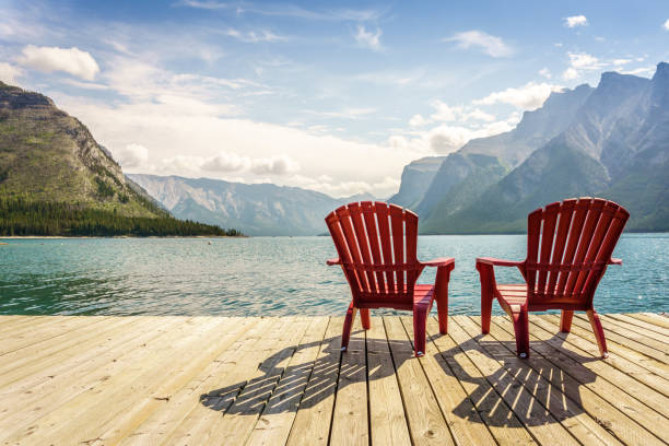 jetty with chairs by minnewanka lake, alberta, canada - canadian beach imagens e fotografias de stock