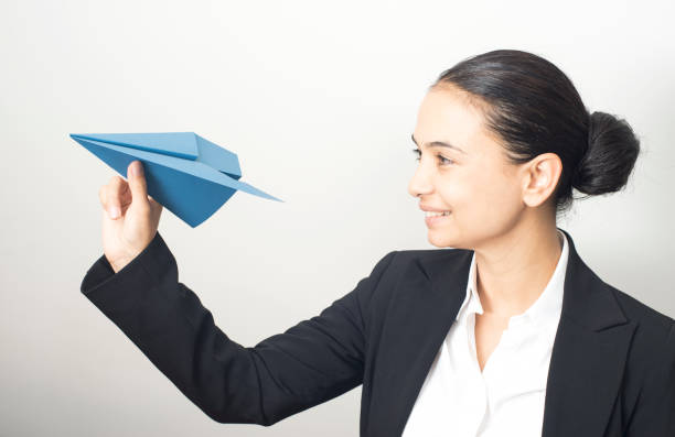 istock Young Woman Playing With Paper Plane 857111466