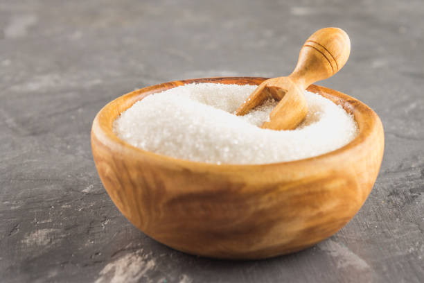 istock White sugar sugar in a wooden plate with a dustpan on a dark background. 857112302