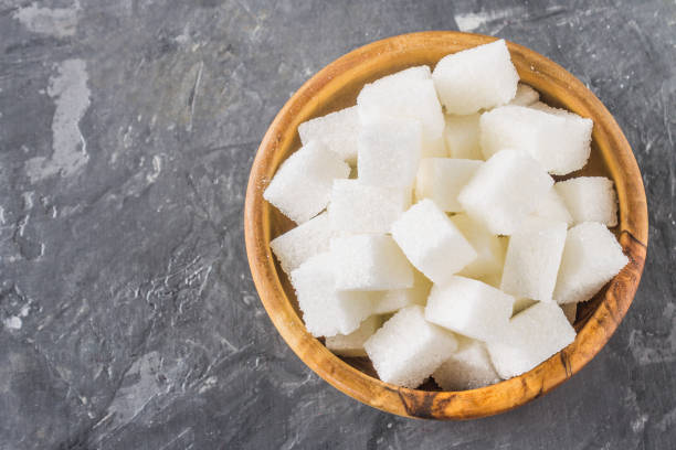 istock wooden bowl with white sugar cubes on dark background 857112426