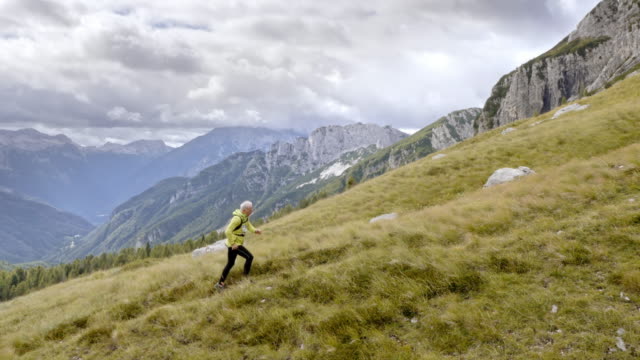 AERIAL Senior male runner running high in the mountains