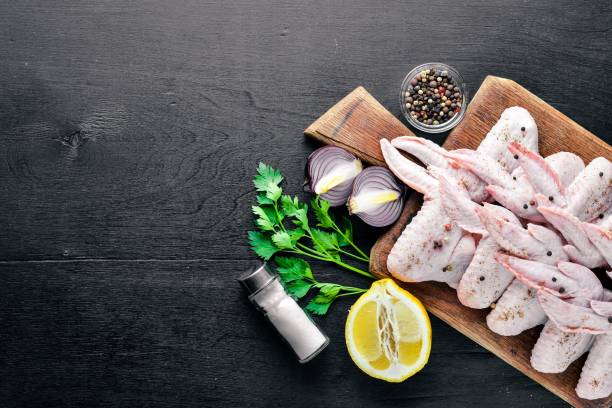 istock Raw chicken wings with spices. On Wooden surface. Top view. 857123066