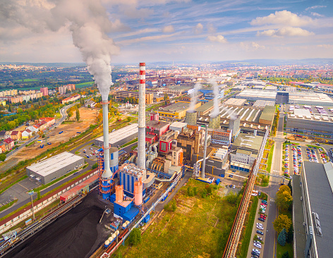 Aerial view of modern combined heat and power plant. Fuming chimney with sulphur removal unit. Heavy industry from above. Power and fuel generation in European Union.