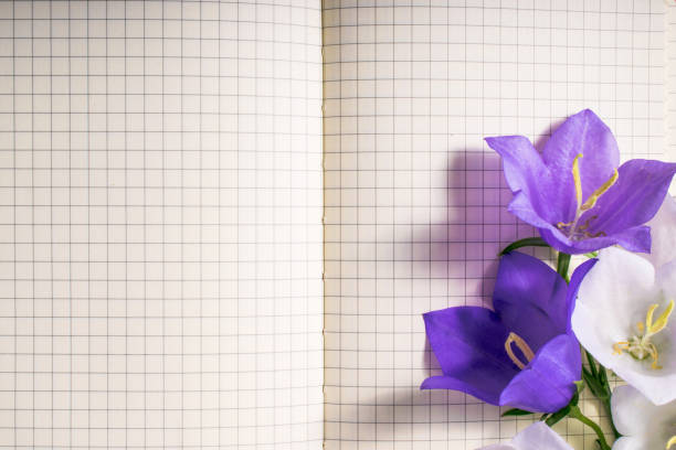 istock blank note book close-up with spring flowers and copy space on wooden background. summer border template. mock-up floral background. sale, greeting and celebration card concept. 857130526