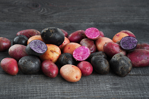 Fresh colorful potatoes on the wooden brown table