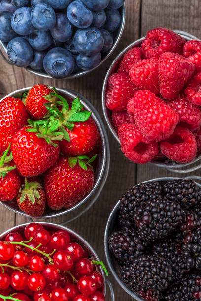 istock Berries overhead close-up assortment in tin cans on wooden table 857138000