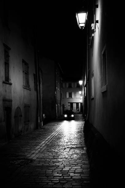 istock Narrow alley, illuminated by headlights and lanterns 857138330