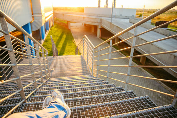 istock man sitting on stairs and looking on sunset 857138972