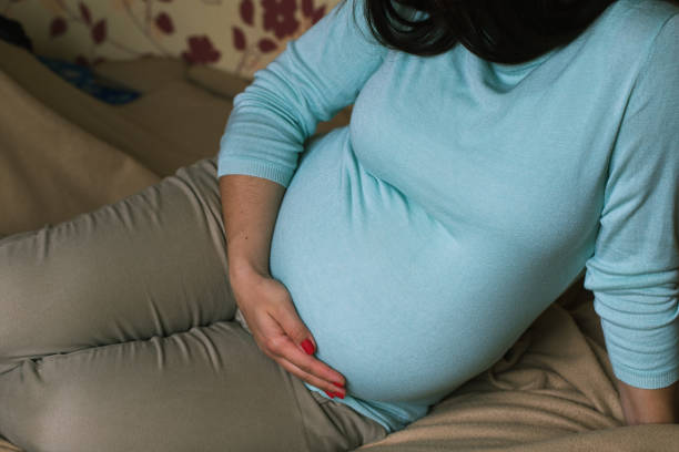 istock Young pregnant woman holds her hands. 857157048