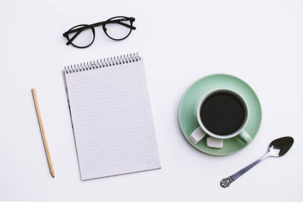 istock Notepad and Cup of coffee on wooden background. 857157162