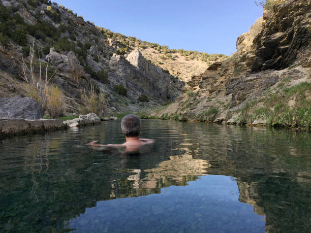 A man soaks in a hot spring in Eastern Nevada stock photo