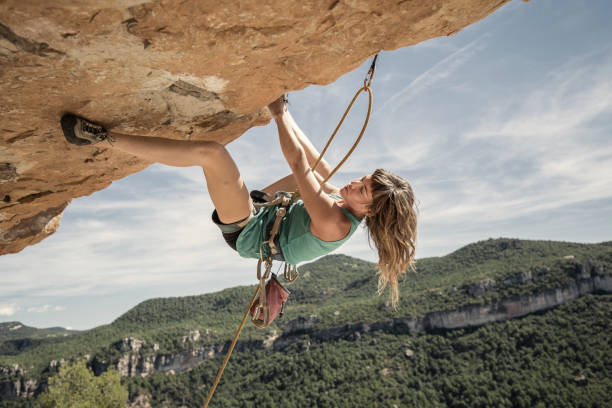 молодая женщина, практикующая скалолазание - climbing rock climbing women determination стоковые фото и изображения