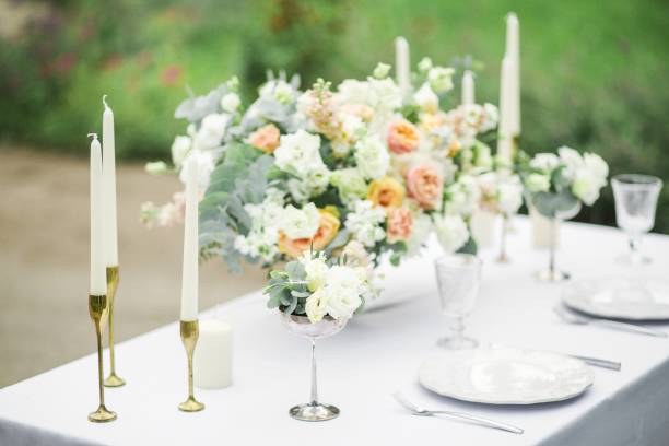 istock decorated wedding table for two with beautiful flower composition, glasses for wine, candles and plates, outdoor, fine art. 857174016