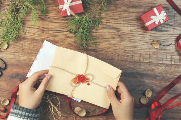 istock woman hand letter with cristmas items on table 857178508