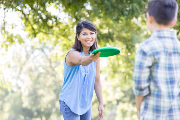 istock Mom and son play with plastic disc in the park 857187260