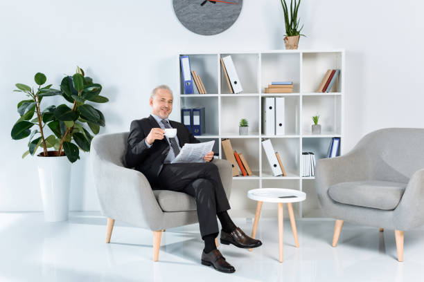 istock businessman in armchair drinking coffee 857193892