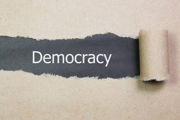 istock Democracy word written under torn paper. 857205650